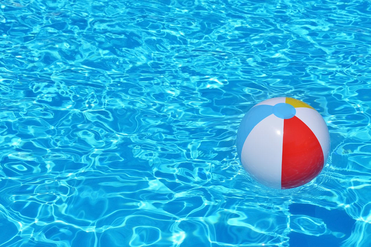 Bola inflable colorida flotando en piscina